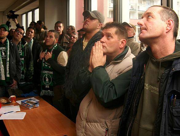 Zasedání zastupitelstva Prahy 10 ohledně způsobu zachování stadionu Ďolíček pro prvoligový fotbal, se konalo v pondělí 12. prosince. Fanoušci netrpělivě sledují vývoj událostí před zasedací místností na obrazovce.