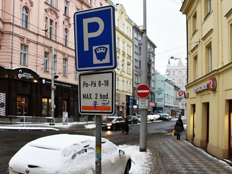 Zasněžené auto v místě s parkovací dobou omezenou dopravní značkou