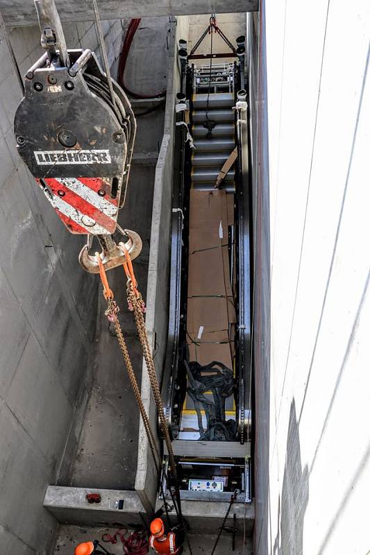 Do nového mostu přes Průběžnou ulici byly instalovány eskalátory, které povedou k železniční zastávce Praha-Zahradní Město.