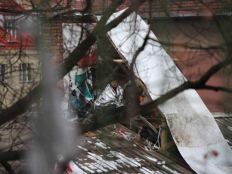 Squatteři nerespektují vývzu soudního exekutora a zůstávají i po vyklizení Kliniky na pražském Žižkově na střeše budovy.