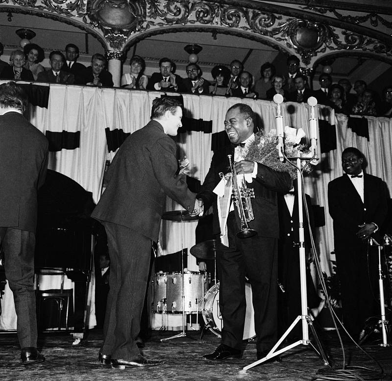 Louis Armstrong v Praze. Na koncert krále jazzu se přišly podívat tehdejší hvězdy populární hudby jako Vlasta Průchová a Karel Gott. Armstrong se při pobytu v Praze také podíval do divadla Semafor a prý vyzkoušel i slavné vepřo, knedlo, zelo.