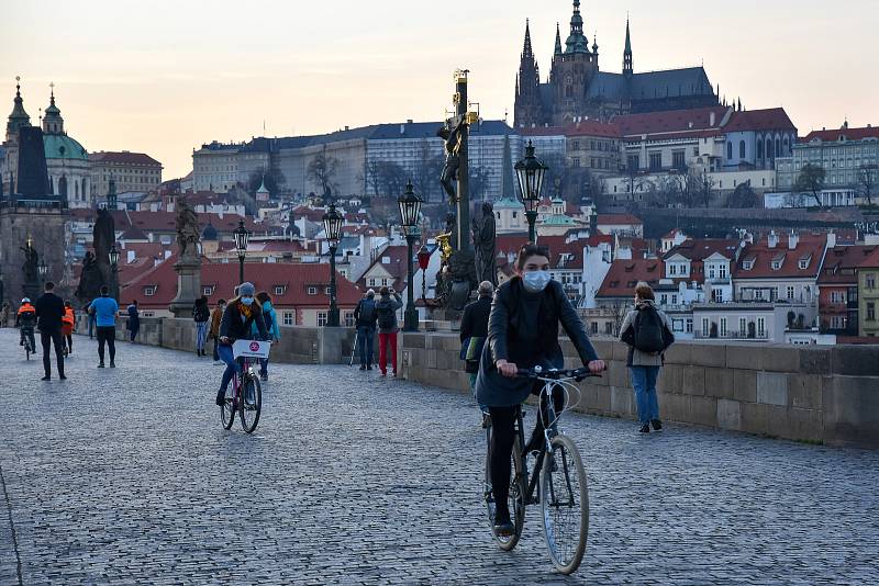 Prázdné ulice Prahy a lidé s rouškami 18. března 2020. Karlův most a pohled na Hradčany.