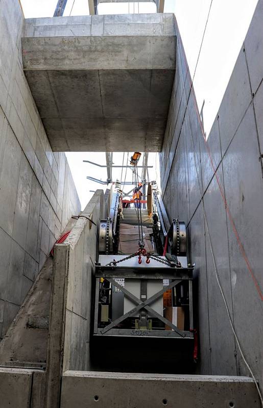 Do nového mostu přes Průběžnou ulici byly instalovány eskalátory, které povedou k železniční zastávce Praha-Zahradní Město.