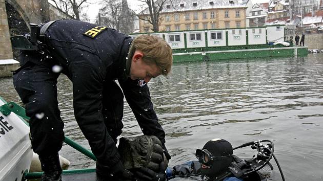 Policejním potápěčům se v obtížných podmínkách podařilo najen nalézt a částečně zdokumentovat dřevěný rošt jednoho z pilířů, ale vyzvednout torzo barokní vázy (na snímku) patřící k soše Antonína Paduánského na Karlově mostě.