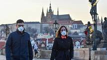 Prázdné ulice Prahy a lidé s rouškami 18. března 2020. Karlův most v době karantény, pohled na Pražský hrad.