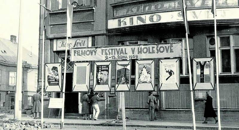 1959 a 1971. Ekonomicky, ale i z hlediska kulturní politiky byly významné Filmové festivaly pracujících. I v Holešově se akce těšila oblibě širokého publika. Na snímku jsou mimo jiné zachyceny poutače, které zvou na další ročník holešovského festivalu.