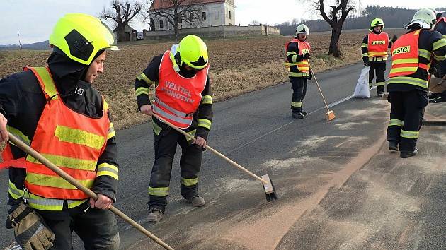 Hasiči ze dvou jednotek likvidují vyteklý olej, který v neděli 16. ledna 2022 znečisti 300 metrů dlouhý úsek silnice mezi Roštínem a Cetechovicemi na Kroměřížsku.