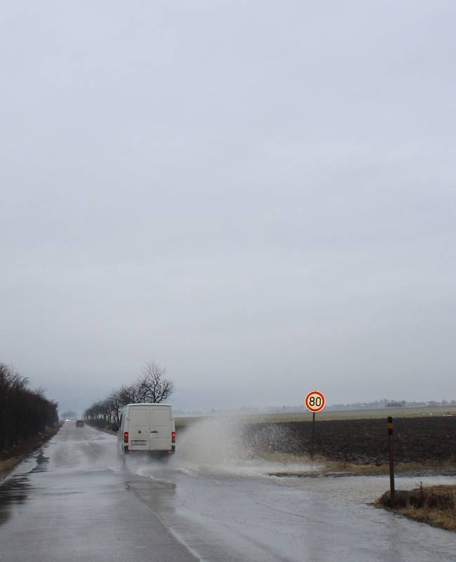 Pole a cesty mezi Zahnašovicemi a Žeranovicemi zalévá voda z tajícího sněhu.