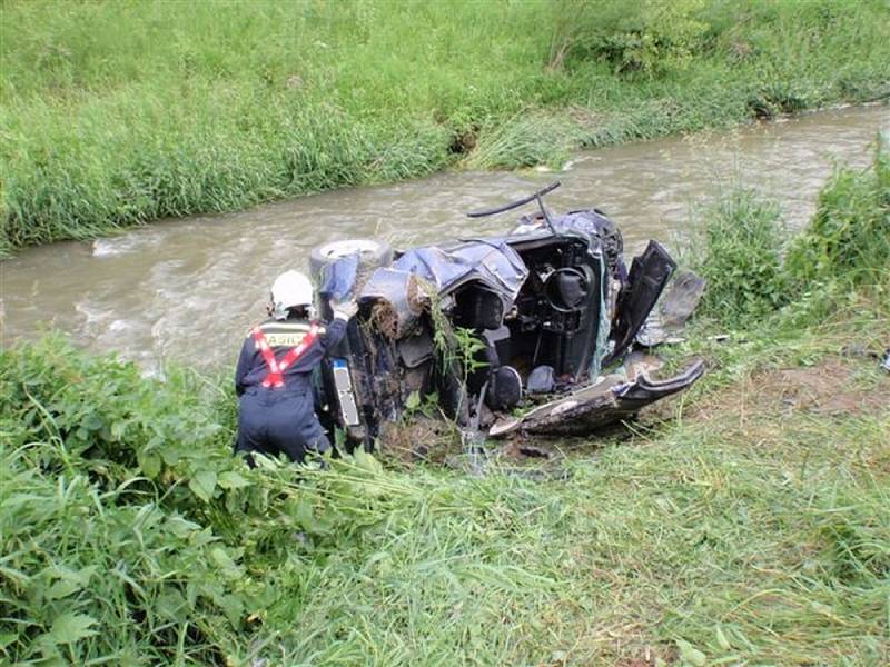 Auto přeletělo přes potok, řidiče museli vystříhat hasiči