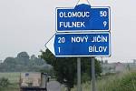 Pár set metrů za Bílovcem, ve směru na Fulnek, ukazuje směrovník, že Olomouc je od místa vzdálena 50 kilometrů.