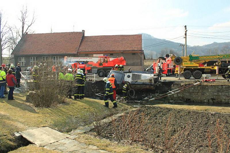 Fréza zakončila svou pouť v potoce v Tiché. Tři jednotky hasičů jí pomáhaly ven.