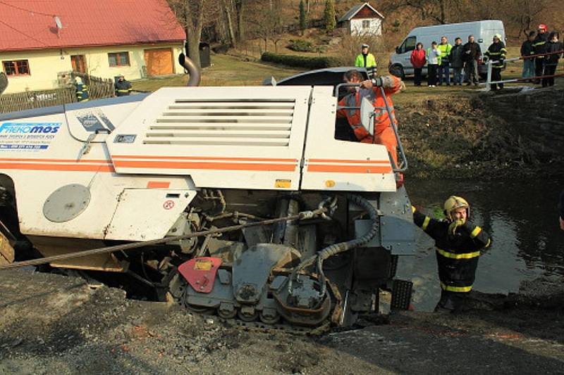 Fréza zakončila svou pouť v potoce v Tiché. Tři jednotky hasičů jí pomáhaly ven.