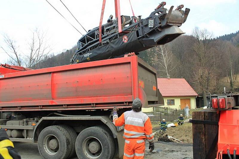 Fréza zakončila svou pouť v potoce v Tiché. Tři jednotky hasičů jí pomáhaly ven.