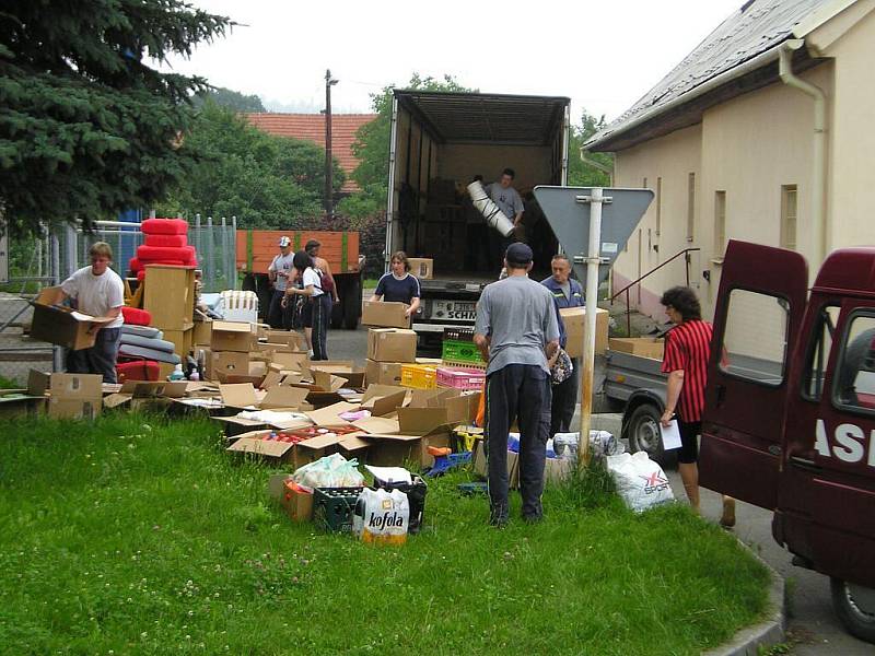 Hasiči vykládají humanitární pomoc, ktreou přivezli do Bludovic, místní části Nového Jičína.