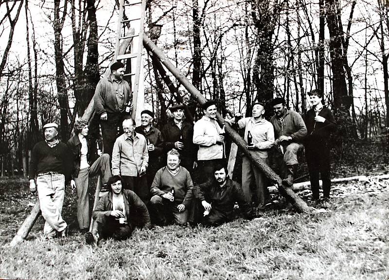 Stavění máje v Dobečkovém hájku se v roce 1975 chopili myslivci. Na žebříku stojí Josef Čapek, pod ním v řadě jsou Zdena Kulák, Zdena Štefek, Miloš Tobiáš, Josef Šmajstrla, Rudolf Kopelec, Jan Haluška, Jaroš Juren, Bedřich Kostelník, Zdena Kostelník. Na z