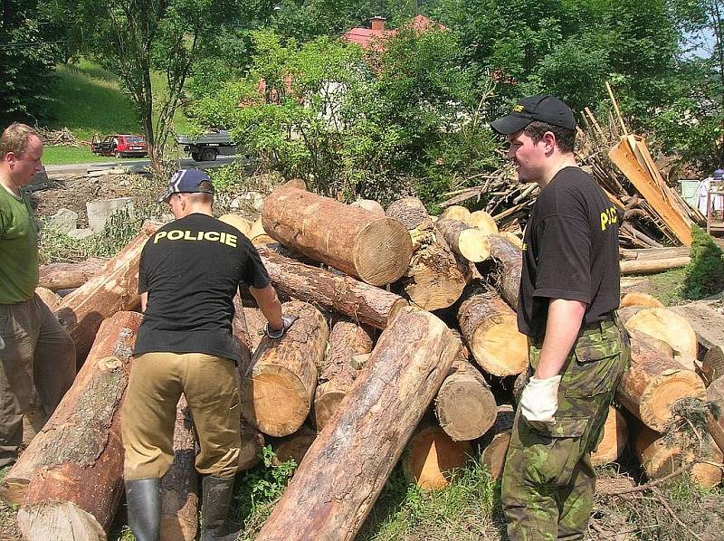 Na dvě desítky příslušníků Policie ČR pomáhají v oblastech, postižených povodní. Obyvatelům nabízejí především pomoc s odklízením naplavenin a poškozeného majetku.