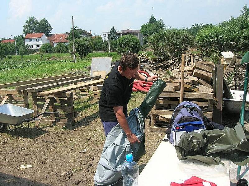 Na dvě desítky příslušníků Policie ČR pomáhají v oblastech, postižených povodní. Obyvatelům nabízejí především pomoc s odklízením naplavenin a poškozeného majetku.