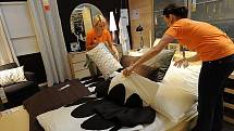 Pracovnice obchodního domu připravují jednu z postelí, která v pátek 19. března v noci bude mít nájemníky.
