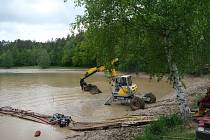 Hasiči čerpali vodu z přehrady na Opavsku a čistili odtok v narušené hrázi, květen 2021.