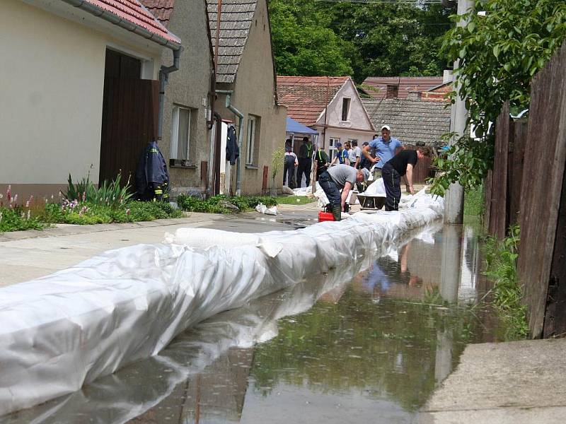 Hasiči evakuují obyvatele a zabezpečují jejich obydlí.