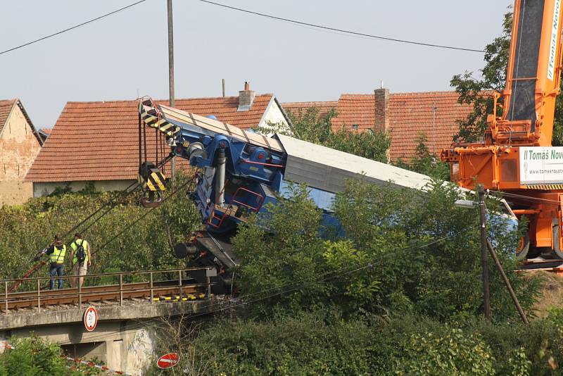 Vykolejený jeřáb je zpátky na trati. Kolem druhé hodiny odpoledne jej zvedl autojeřáb. Aby se dostal k místu nehody, bylo potřeba vysypat štěrkem trať, pomohly i betonové bloky.