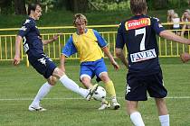 Záložník narychlo seskládaného Slováckého výběru Marek Janoušek (ve žlutém) se snaží odklidit míč proti ligovému soupeři do bezpečí. 