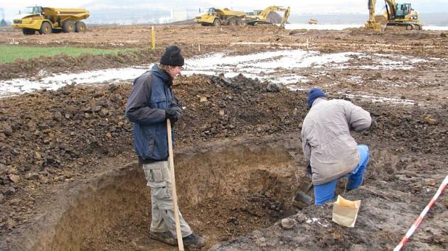 Pracovníci z Ústavu archeologické památkové péče Brno odkrývají polovinu sídlištního objektu.