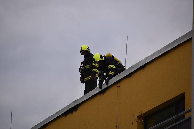 Hustý dým valící se ze střechy a silný zápach. V adamovské ulici Ronovská začalo v pondělí hořet v jedné z tamních bytovek. Podle prvotních informací hasičů se oheň snažili před pátou hodinou odpoledne uhasit hadicí dělníci, kteří na střeše domu pracovali