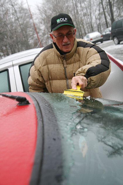 Ledovka komplikovala provoz v regionu od nedělního večera. Na snímku řidič čistí auto od ledu v adamovské ulici Družstevní.