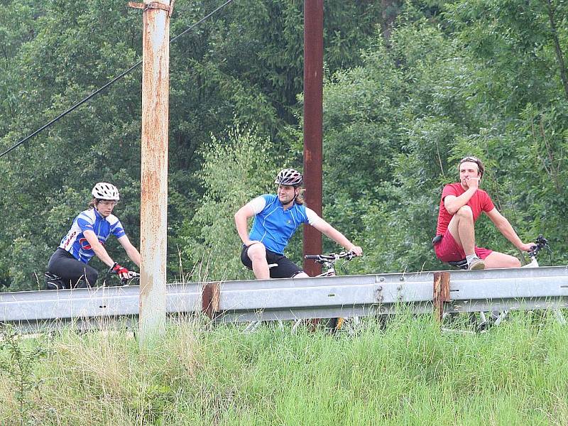 Devátý ročník napínavého klání bicyklistů na lávce přes vodu málem zhatil déšť. Pořadatelé museli opravit i vypuštěné duše. Ty fošnu drží.