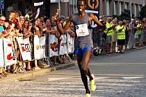 Keňan Silas Mwetich probíhá jako první cílem Půlmaratonu Moravským krasem.