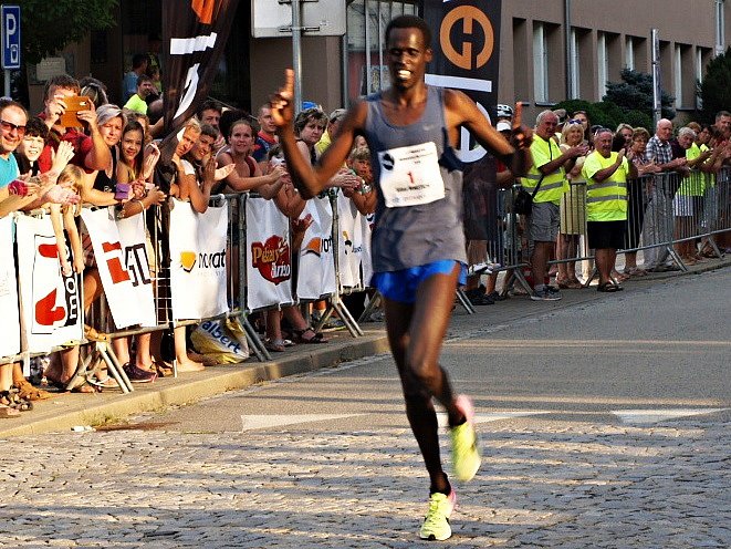 Keňan Silas Mwetich probíhá jako první cílem Půlmaratonu Moravským krasem.