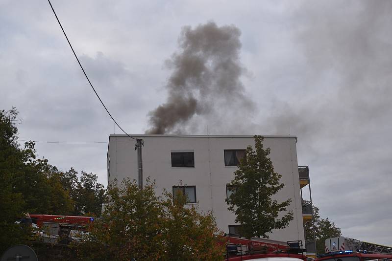 Hustý dým valící se ze střechy a silný zápach. V adamovské ulici Ronovská začalo v pondělí hořet v jedné z tamních bytovek. Podle prvotních informací hasičů se oheň snažili před pátou hodinou odpoledne uhasit hadicí dělníci, kteří na střeše domu pracovali