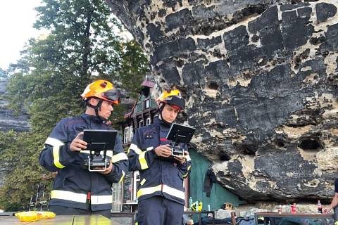 Posádka hasičů z Jihomoravského kraje pilotovala dron a s dalším speciální technikou hledala skrytá ohniska při požáru lesa v Českém Švýcarsku. Na snímku vlevo Lukáš Bubeníček a Štěpán Komosný.