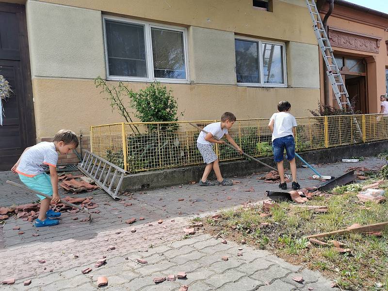 Lidé v Moravské Nové Vsi vyklízejí suť z poškozených domů. Pomáhají i děti.