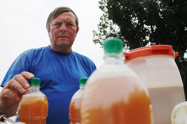 Miloslav Machuča starší nabízí plastové láhve naplněné burčákem na břehu rybníku Apollo mezi Břeclaví a Lednicí.