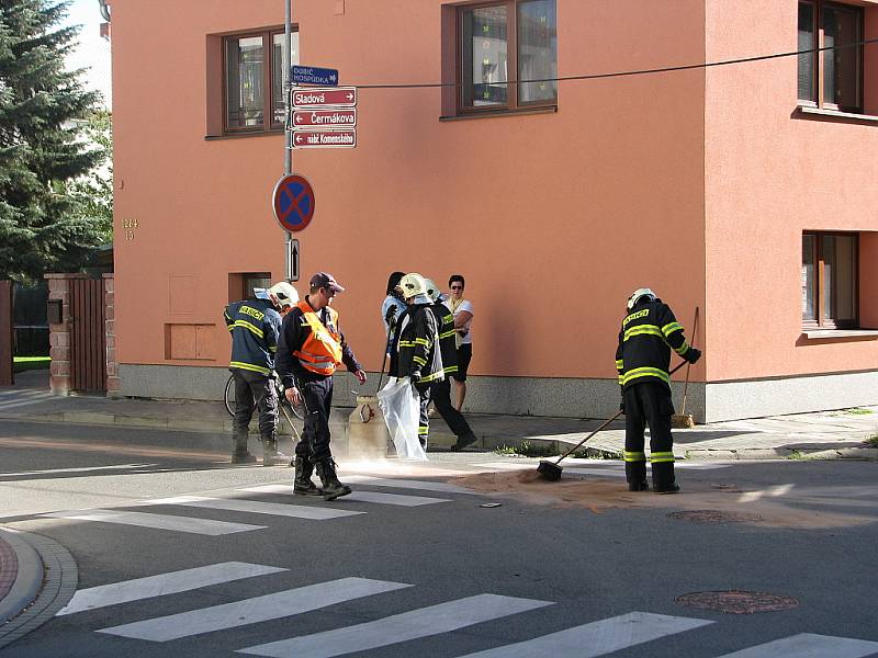 V místě nehody na křižovatce ulic Sladová, Fintajslova a Čermákova řídí policisté dopravu a hasiči zasypávají uniklé pohonné kapaliny sorbentem.