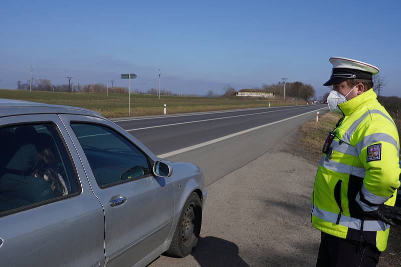 Omezení cestování mezi okresy. Na dodržování opatření v pondělí po poledni dohlížela policejní hlídka také na tahu mezi Břeclaví a Hodonínem. Kontrolovala řidiče nedaleko Lužic.