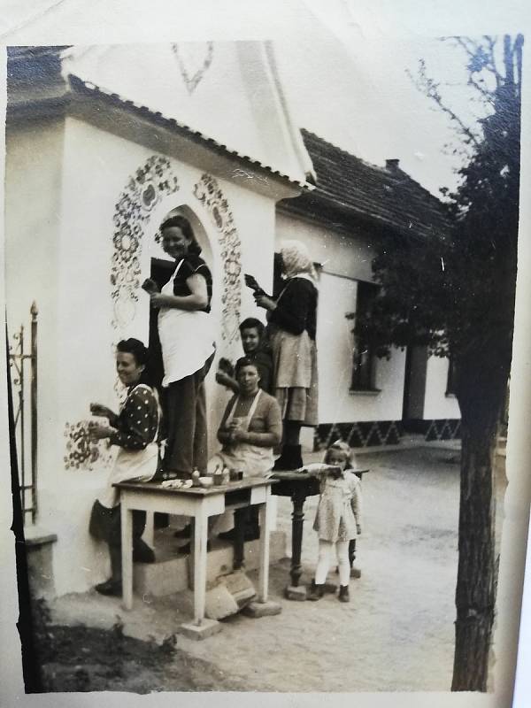 Obrázky ze života v Kosticích. Malování kaple sv. Kříže u hřbitova - krásný bohatý ornament od místních žen. Rok 1958 - ženy z uličky: p. Malacková, p. Turečková. p. Trčková. Vedle původní dům Trčkových, který tam dnes již nestojí. Poskytli Blažejovi