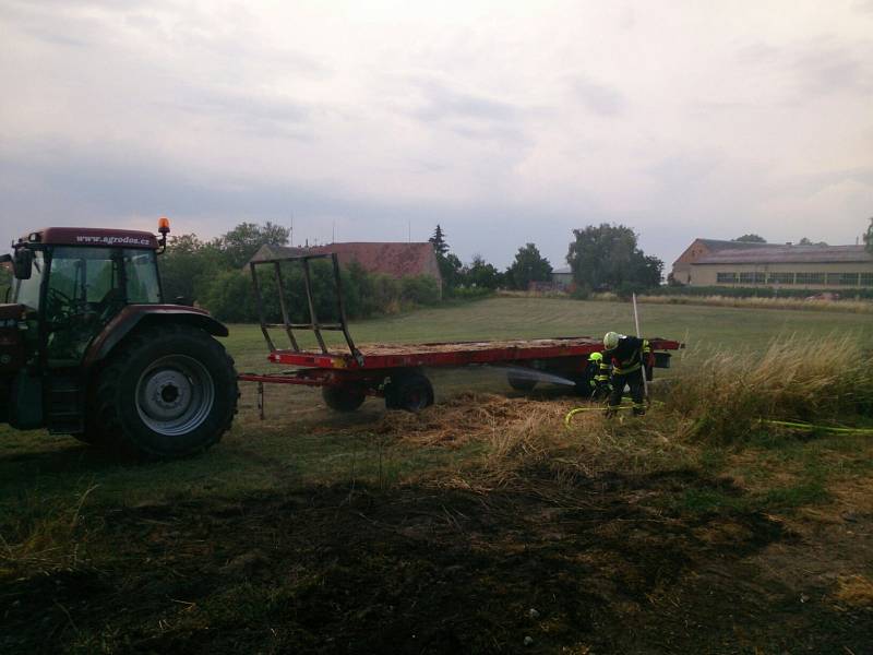 Hasiči v sobotu zasahovali u požáru v Uherčicích. Na poli začala hořet sláma na valníku.