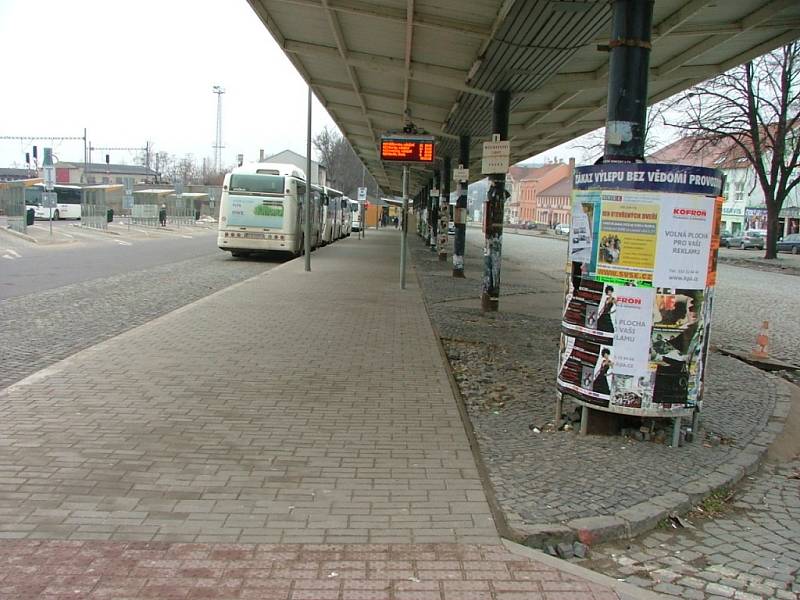 Na vlakovém nádraží se povalují kusy hadrů a papíru, v bezprostředním okolí sousedního autobusového je pak poničená kostková dlažba chodníků a vidět je i další nepořádek.