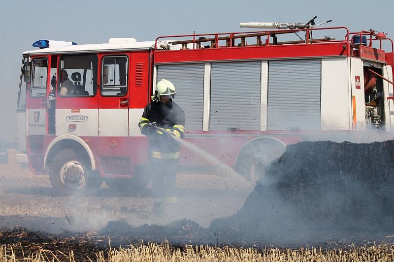 Na strništi u Břežan hasiči likvidovali požár několika desítek balíků slámy.