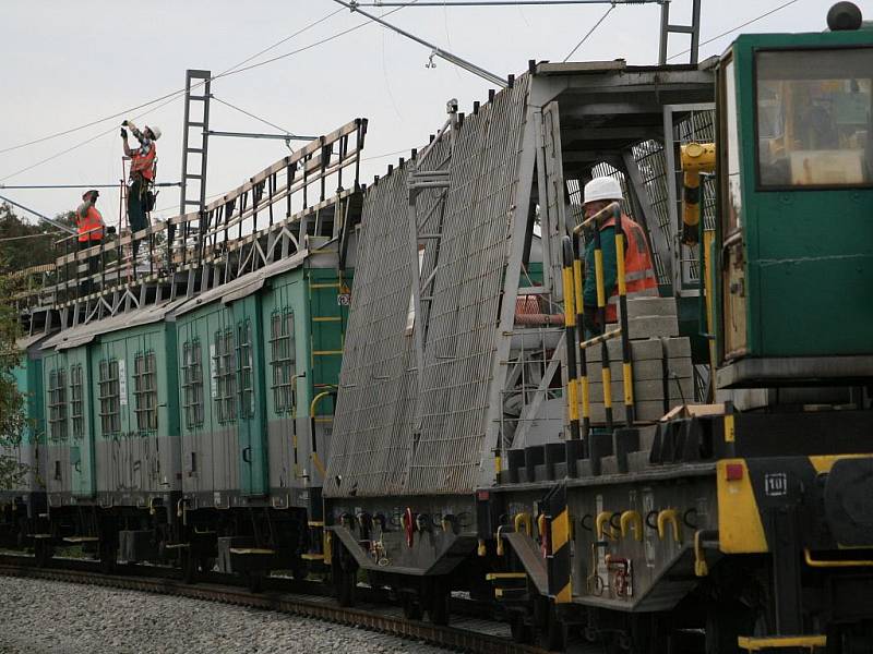 Dělníci natahují posledních pár metrů elektrického trakčního vedení. 