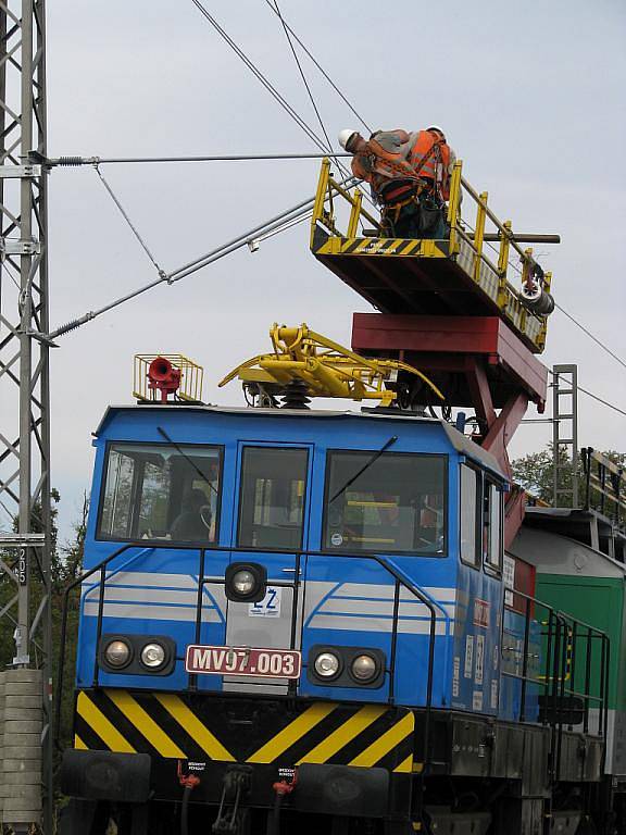 Dělníci natahují posledních pár metrů elektrického trakčního vedení. 