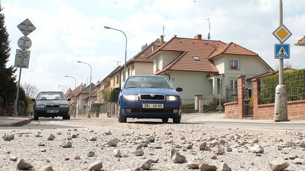 NEBEZPEČÍ U PŘECHODU. Více než měsíc od chvíle, kdy dělníci zasypali vybagrovanou silnici v ulici Legionářská ve Znojmě, není povrch vozovky v původním stavu.