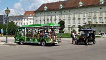 Z letního výletu do Vídně. Rozmanité dopravní prostředky pro turisty v Hofburgu.
