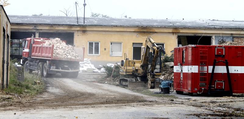 Za pomoci těžké techniky demolují hasiči garáže bývalého autoparku policie u Pražské ulice ve Znojmě.