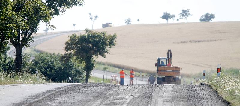 Silničáři opravují v tropických červencových teplotách silnici mezi kasárenskou křižovatkou a Citonicemi.