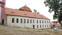 Šedá budova staré školy v areálu Louckého kláštera ve Znojmě má nyní rozbitá okna a městu dělá spíš ostudu.