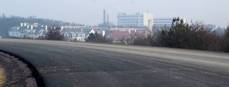 Dělníci i v mrazivých dnech pokračují na stavbě části obchvatu Znojma. V mrazivém lednovém dni se v dálce z mlhy noří znojemská nemocnice.